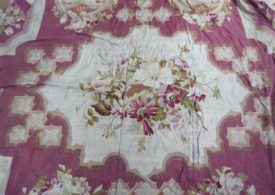 An Aubusson carpet, wine coloured field